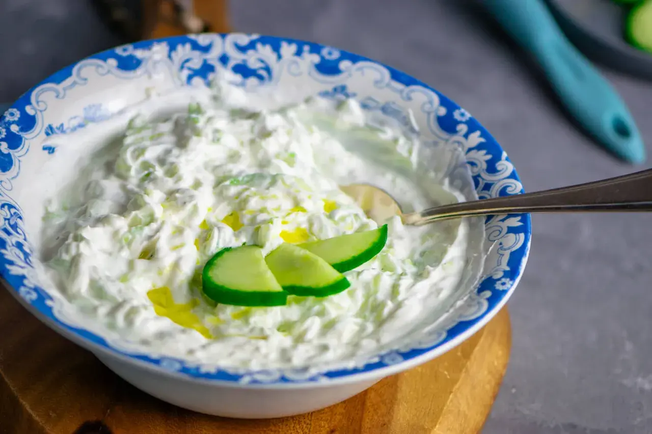 Cremiger Tzatziki-Dip mit Gurkenstücken und Olivenöl, perfekt für dein nächstes Tzatziki Rezept.
