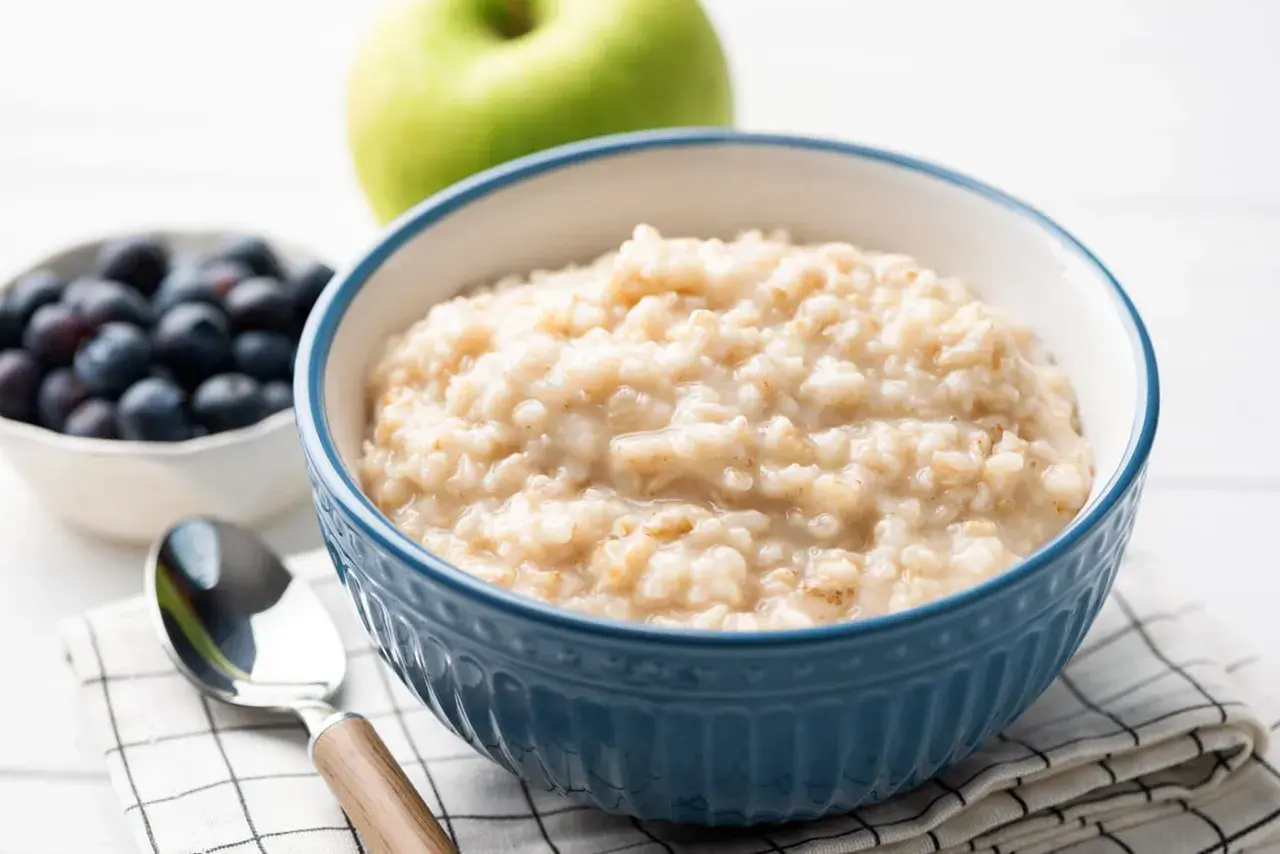 Herzhaftes Porridge-Rezept mit Blaubeeren und Apfel. Ein Löffel wartet auf den Genuss.