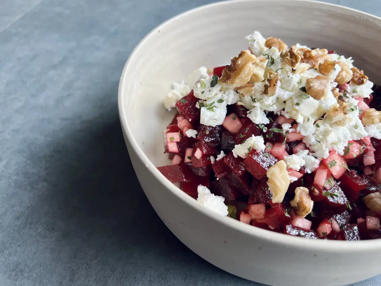 Schüssel mit roter Bete, Feta und Walnüssen. Ein köstlicher roter Bete Feta Salat, garniert mit Kräutern.