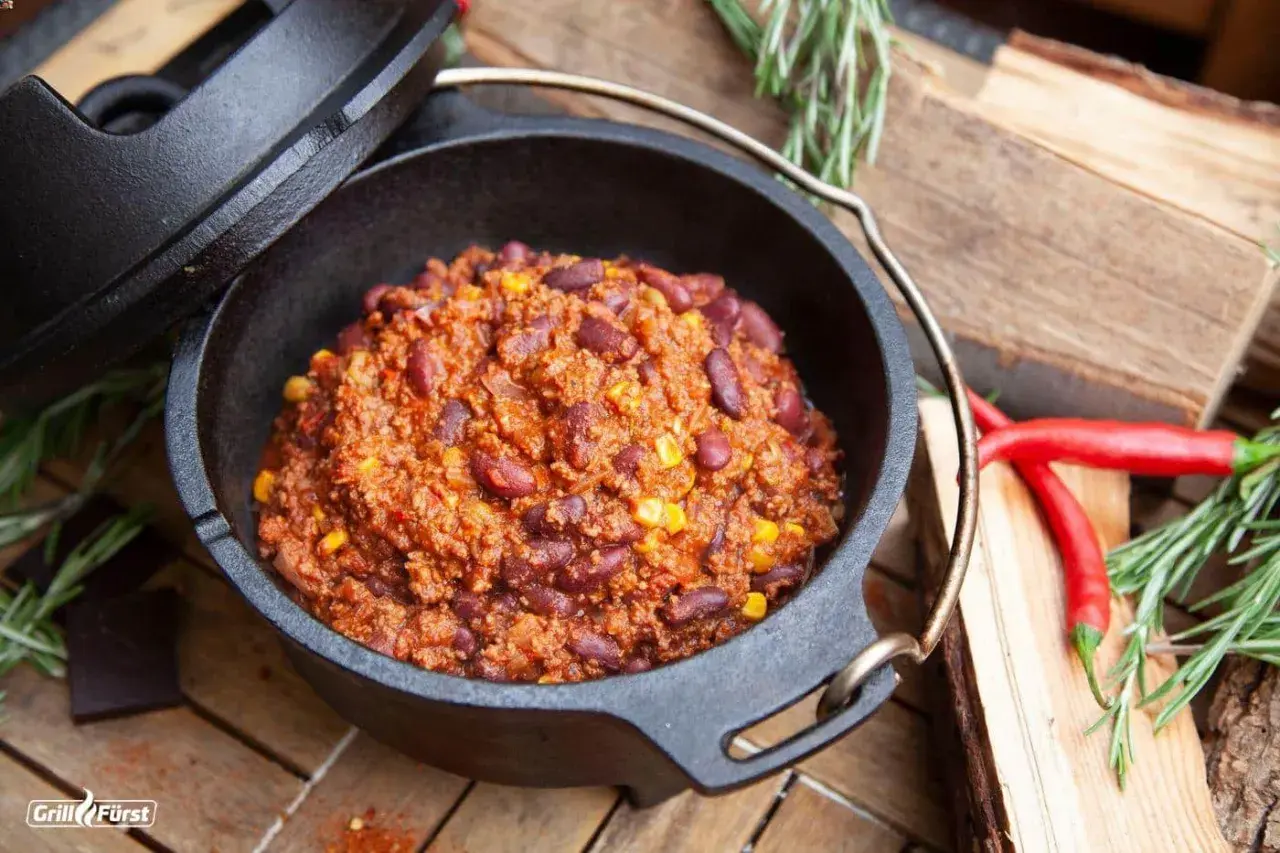 Herzhaftes Chili con Carne, dampfend im Dutch Oven, mit roten Bohnen und Mais. Perfekt für kalte Tage!
