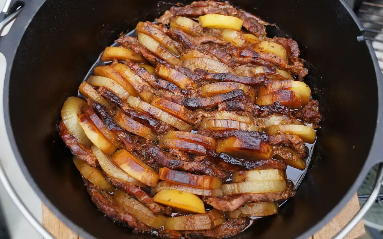 Schichtfleisch im Dutch Oven: saftige Fleischscheiben und Kartoffeln, goldbraun geschmort. Ein Festmahl!