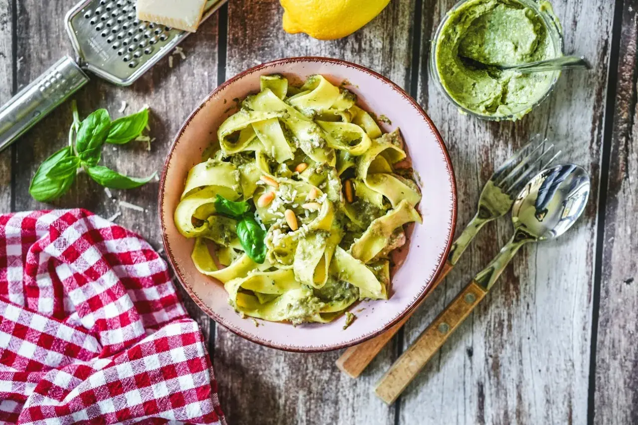 Bandnudeln mit cremigem Avocado Pesto, garniert mit Pinienkernen und Basilikum. Ein köstliches Gericht, das Lust auf mehr macht.