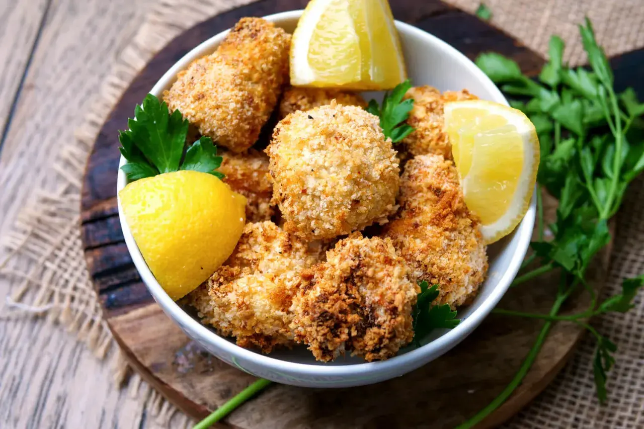 Knusprige Blumenkohl-Bites aus dem Airfryer, garniert mit Zitrone und Petersilie.