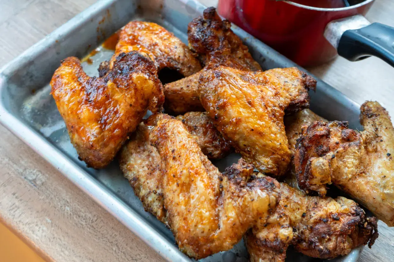 Saftige, goldbraune Buffalo Wings in einer Metallschale, bereit zum Genießen.