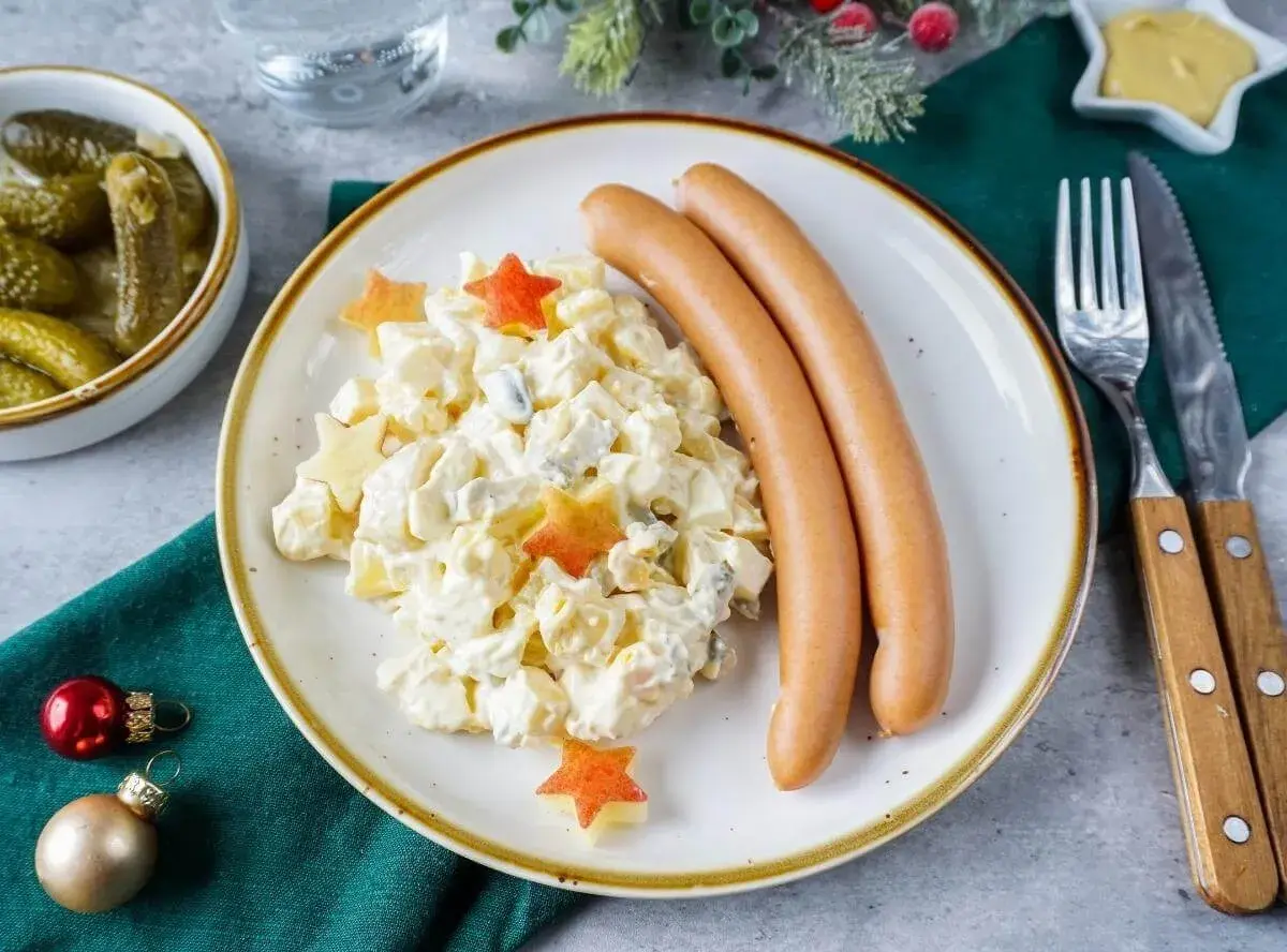 Kartoffelsalat mit Würstchen und Sternen – ein Klassiker der 10 besten Weihnachtsessen. Dazu Cornichons und Senf.