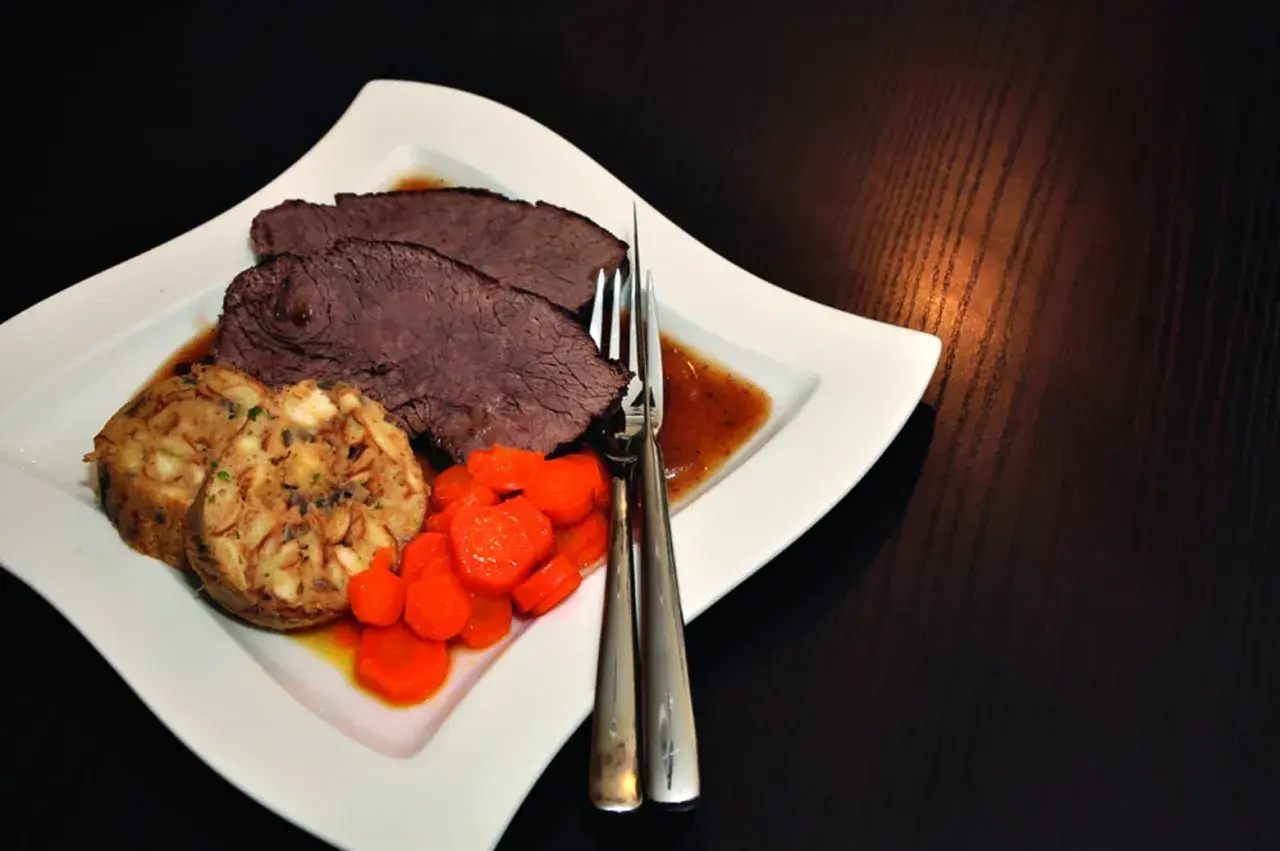 Saftiger Rinderbraten im Dutch Oven, serviert mit Klößen und Karotten. Ein Klassiker, der auf der Zunge zergeht.