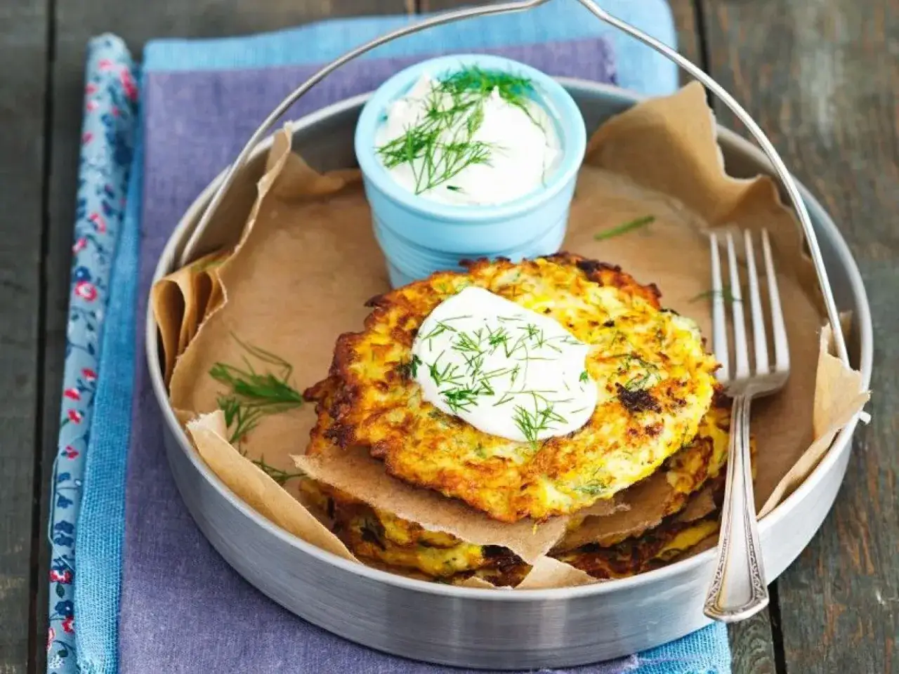 Goldbraune Zucchinipuffer, ein k&ouml;stliches Gericht, das sich perfekt f&uuml;r gelbe Zucchini Rezepte eignet. Serviert mit einem Klecks Dill-Dip.