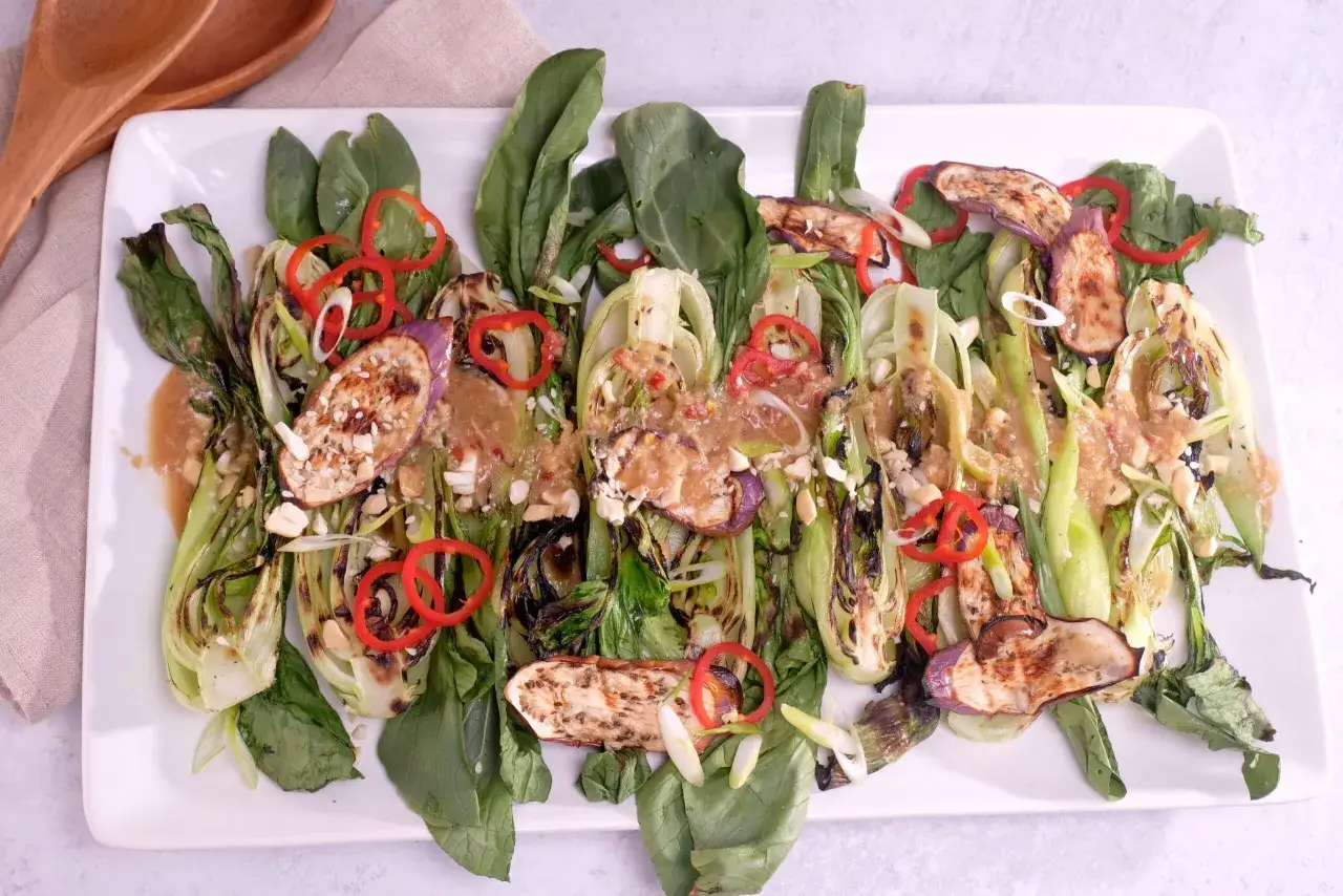 Gegrillter Pak Choi mit Auberginenscheiben, roten Chiliringen und Erdnüssen. Ein köstliches Gericht, das sich gut für Pak Choi Rezepte eignet.
