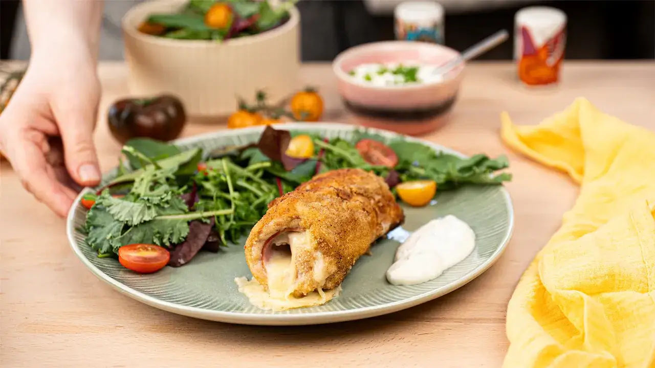 Marinierter Putenschnitzel mit geschmolzenem K&auml;se, serviert mit Salat und Dip. Perfekt zum Grillen!