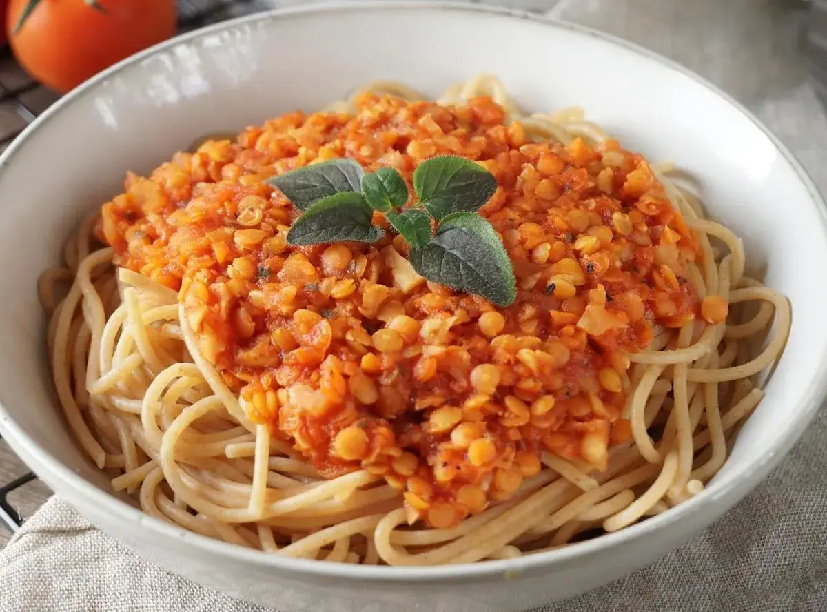 Herzhafte vegetarische Bolognese aus Linsen auf Spaghetti, garniert mit frischen Kräutern. Ein Genuss für alle!