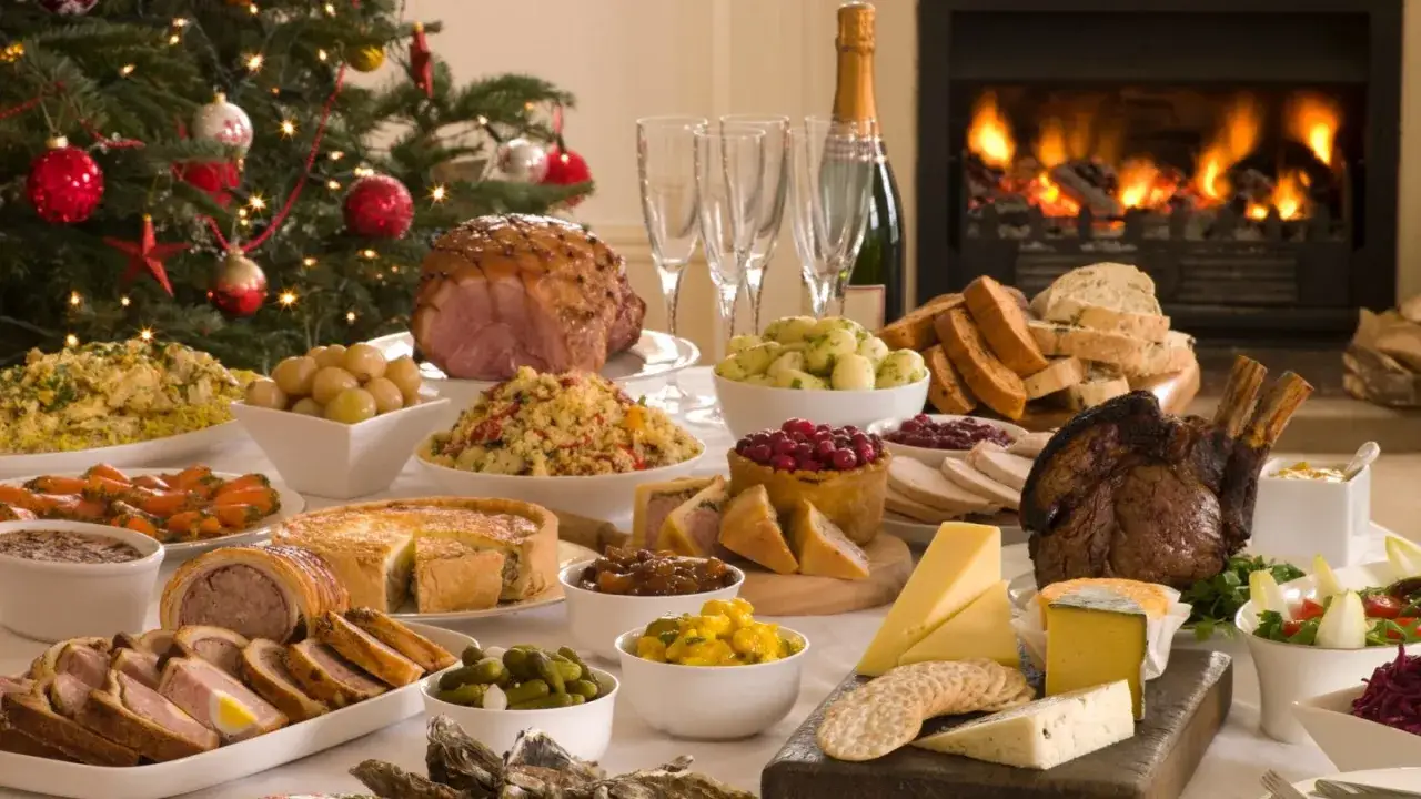 Festlicher Tisch mit vielen Köstlichkeiten, die die 10 besten Weihnachtsessen darstellen könnten: Braten, Schinken, Pasteten, Salate und mehr.