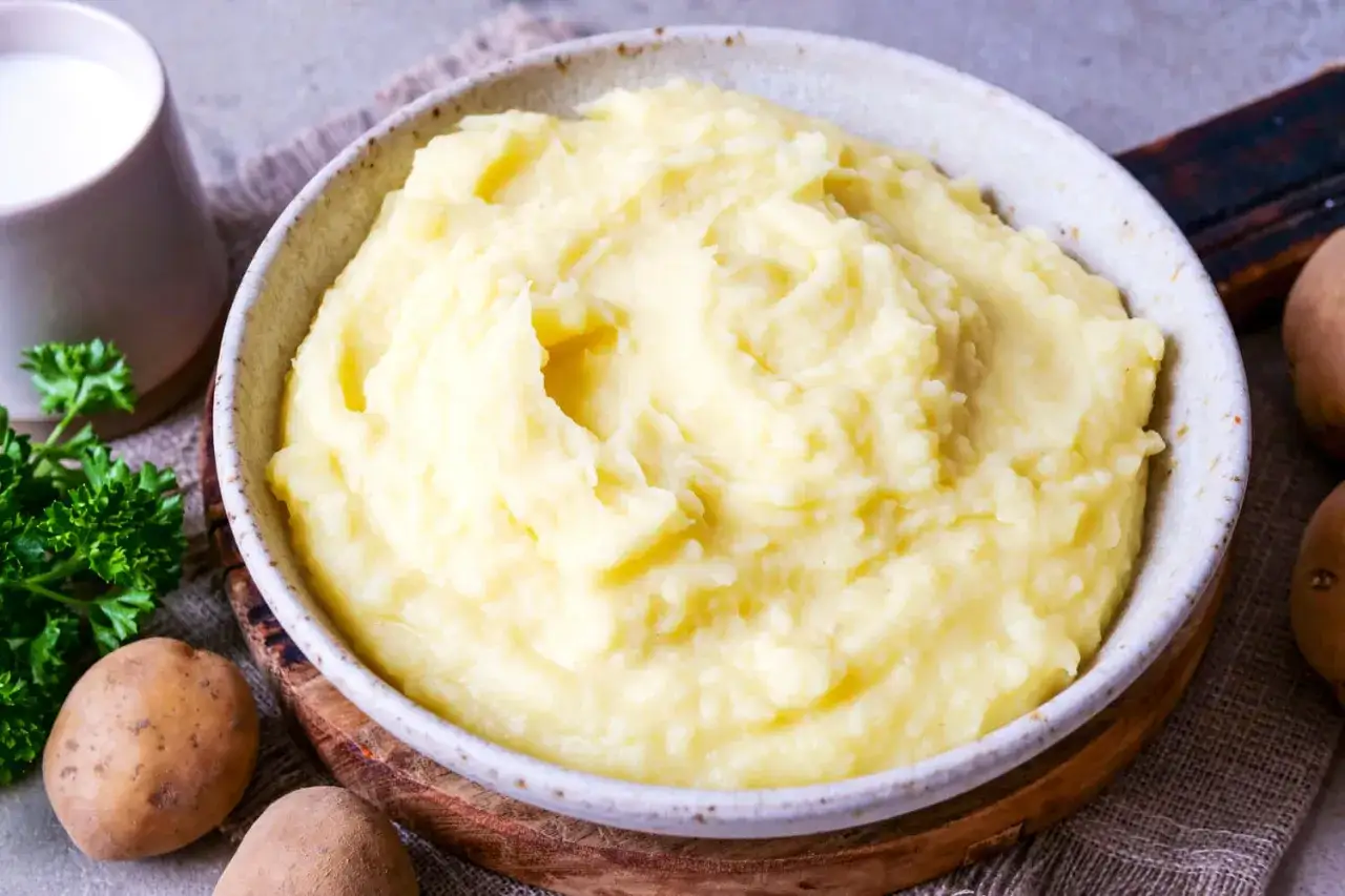 Cremiger Kartoffelbrei, perfekt f&uuml;r Ihr n&auml;chstes Kartoffelbrei Rezept. Dazu ein Krug Milch und frische Petersilie.