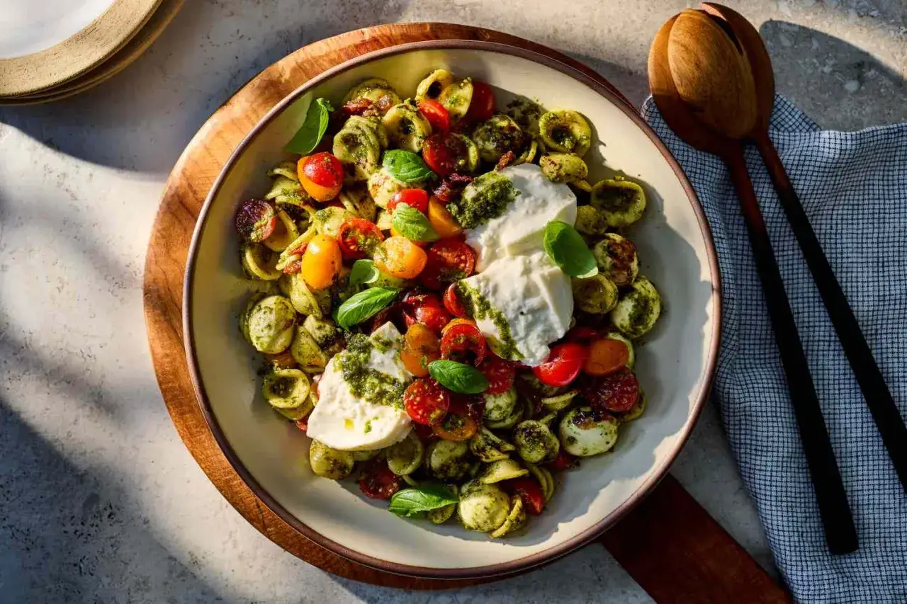 Orecchiette-Nudelsalat mit Kirschtomaten, Mozzarella und frischem Basilikum, verfeinert mit Pesto. Ein leichter und sommerlicher Genuss.