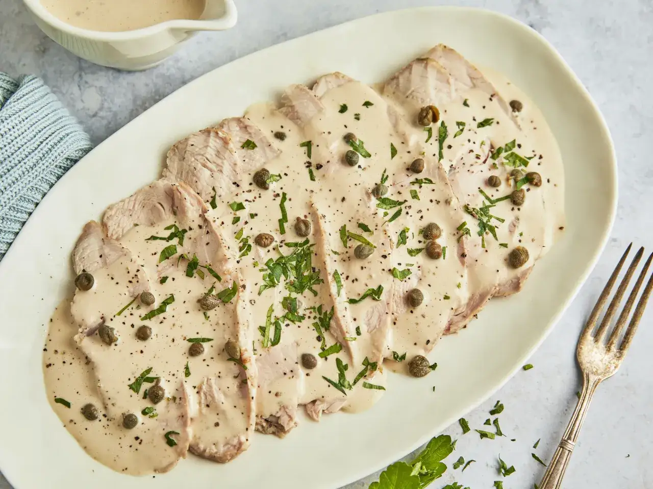 Vitello Tonnato Rezept: D&uuml;nne Kalbfleischscheiben mit cremiger Thunfischsauce, Kapern und Petersilie. Ein Klassiker der italienischen K&uuml;che.