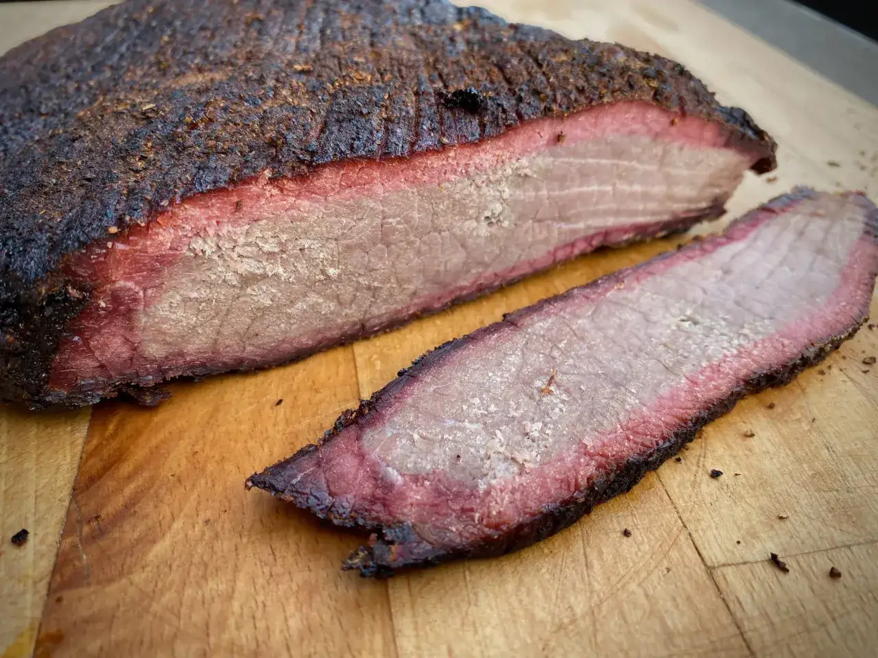 Beef Brisket: welches Fleisch ist das? Ein saftiges St&uuml;ck Rinderbrust mit rauchiger Kruste und zartem, rosa Fleisch.