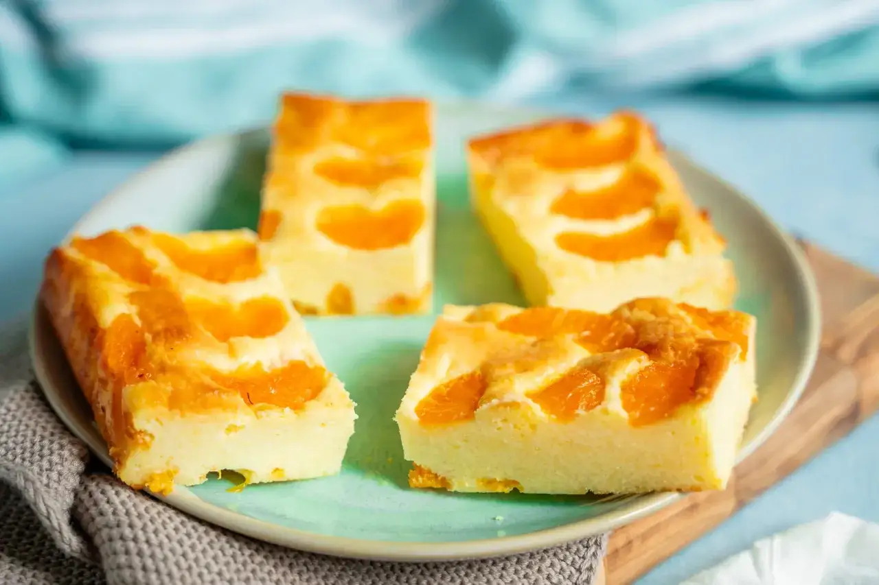 Vier Stücke saftiger faule weiber kuchen mit Mandarinenstücken auf einem Teller.