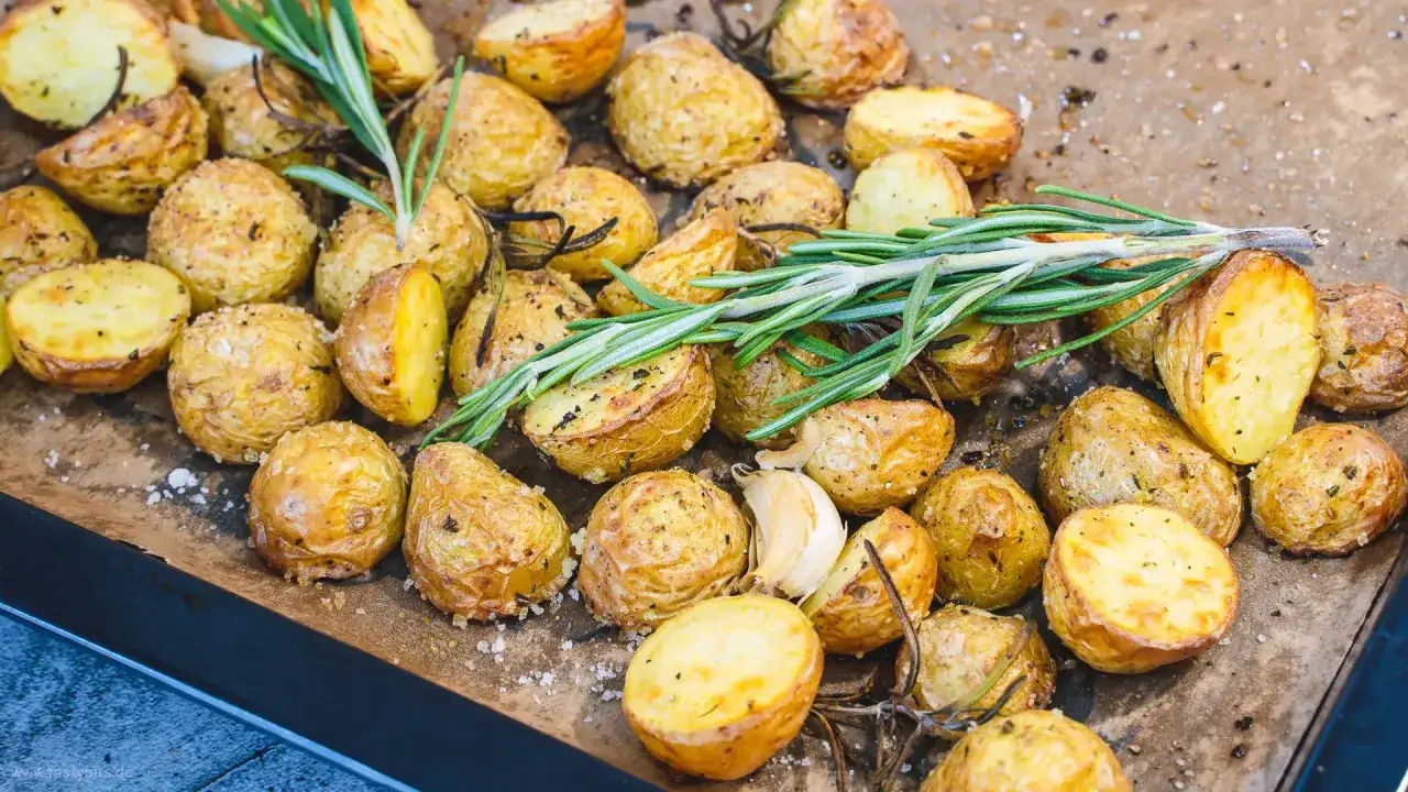 Knusprige rosmarinkartoffeln vom Blech, goldbraun gebacken, mit frischem Rosmarin und Knoblauch garniert. Ein Genuss!