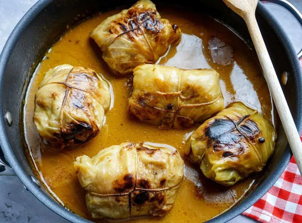 F&uuml;nf Kohlrouladen im Topf, bereit f&uuml;r ein k&ouml;stliches Kohlrouladen Rezept.